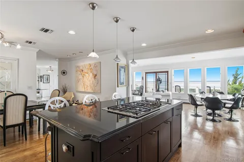 a kitchen with granite countertop a table chairs stove and wooden floor