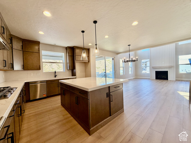 1595 West Canyon Rim Road, Unit 630 Lehi, UT 84048 - Photo 11 of 41 Open-concept kitchen and living area featuring a large center island with a stone countertop, wood-finish flooring, a contemporary fireplace with shiplap detailing, and recessed lighting