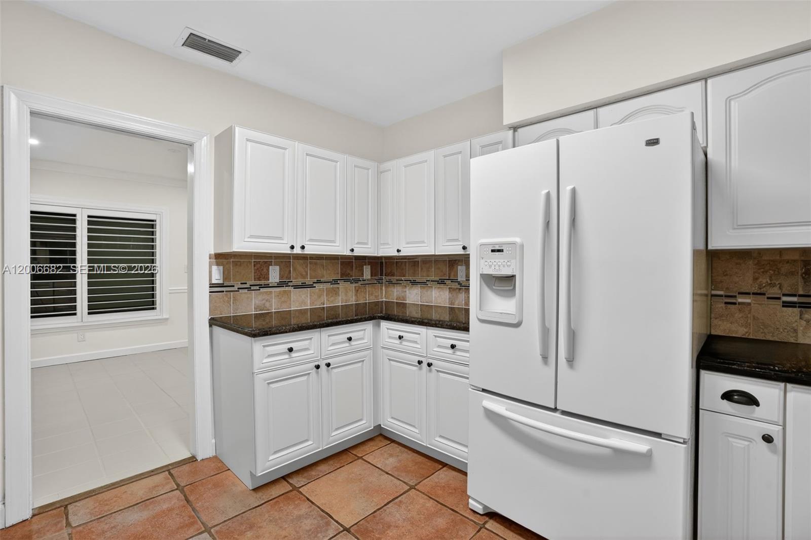 1435 Blue Road Coral Gables, FL 33146 - Photo 13 of 31 a kitchen with white cabinets and white appliances