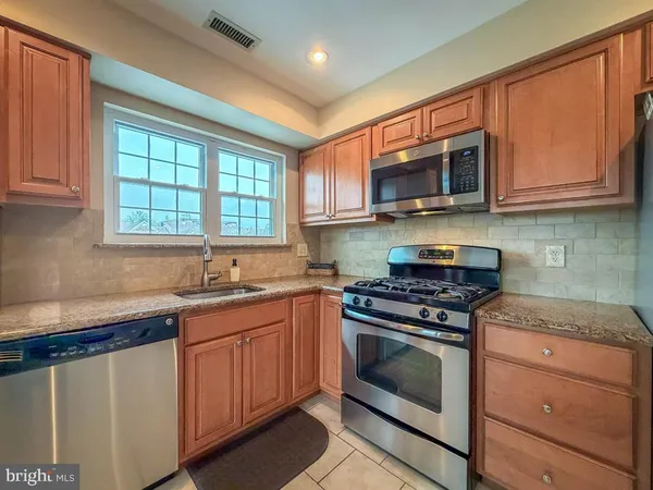 a kitchen with stainless steel appliances granite countertop a refrigerator stove a sink dishwasher and microwave