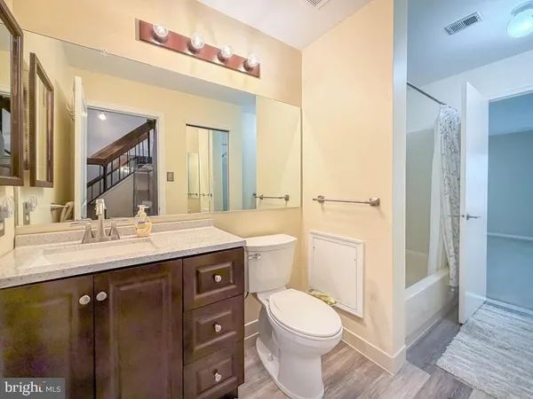 a bathroom with a sink vanity mirror and toilet