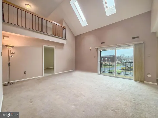 a view of an empty room with window and cabinet