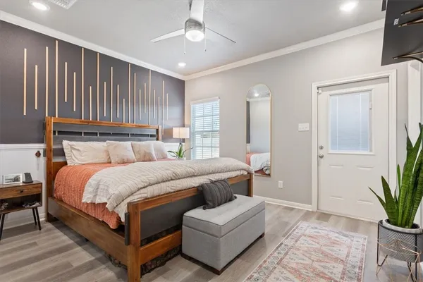 a bedroom with a large bed and a potted plant