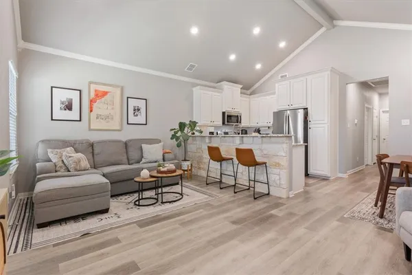 a living room with furniture and a dining table with kitchen view