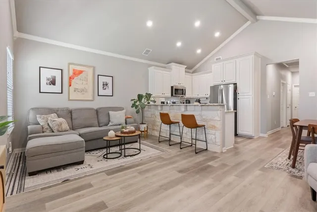 a living room with furniture and a dining table with kitchen view
