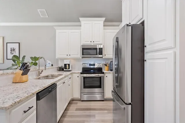 a kitchen with stainless steel appliances granite countertop a refrigerator sink and stove