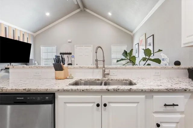 a kitchen with granite countertop a sink and a wooden floor