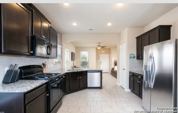 a kitchen with stainless steel appliances granite countertop a sink a stove and a refrigerator