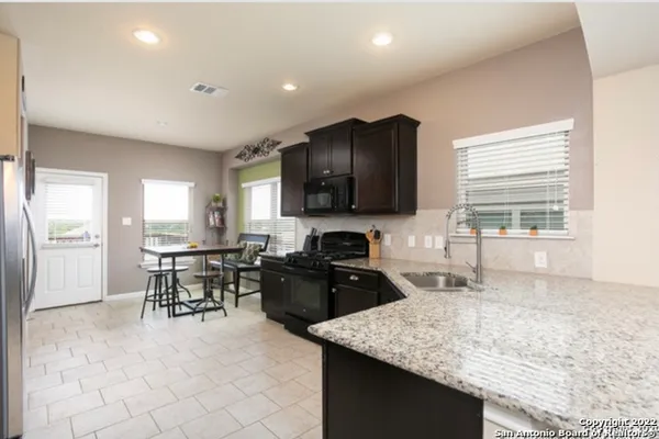 a kitchen with granite countertop sink cabinets and stainless steel appliances