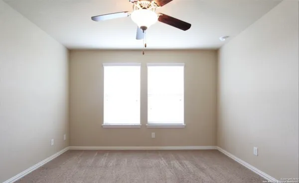 an empty room with a window and a fan