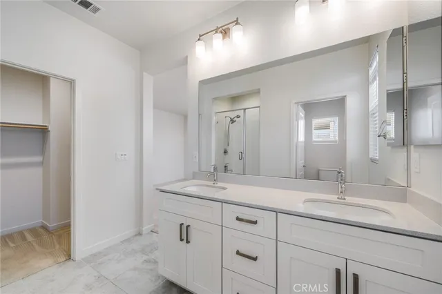 a bathroom with double sink and a mirror