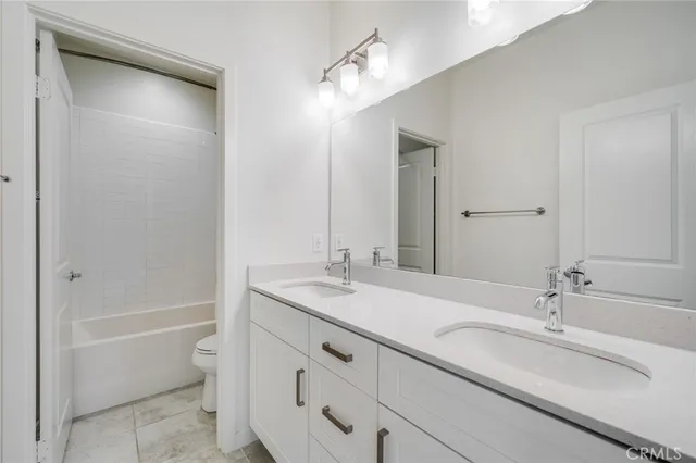 a bathroom with a granite countertop sink mirror and a bathtub