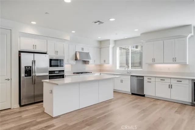a kitchen with white cabinets and stainless steel appliances
