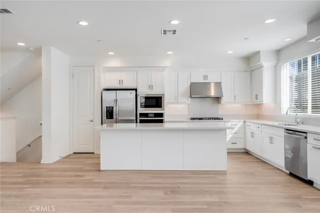 a kitchen with stainless steel appliances granite countertop a stove top oven a sink and a granite counter tops