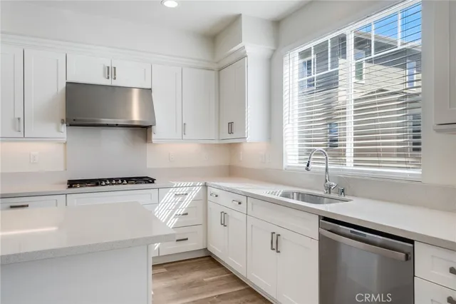a kitchen with granite countertop white cabinets and a sink