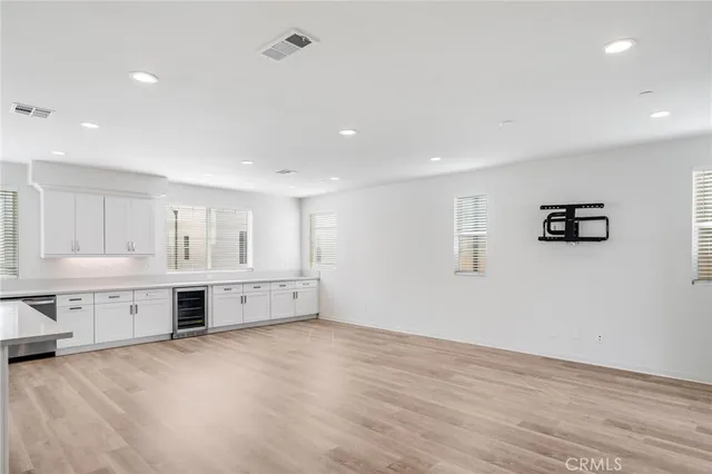 a large white kitchen with a sink cabinets and wooden floor