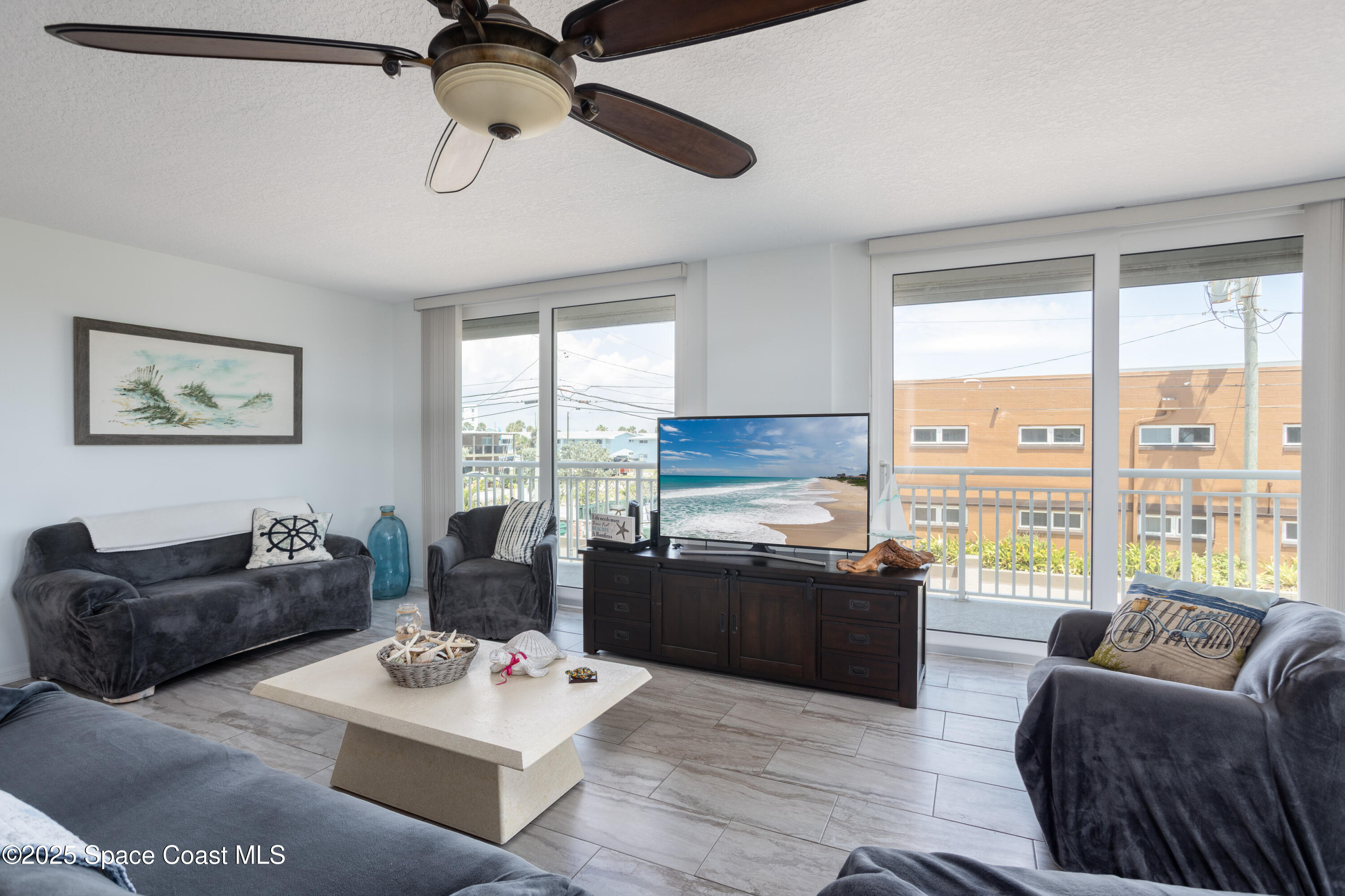 3450 Ocean Beach Boulevard, Unit 201 Cocoa Beach, FL 32931 - Photo 13 of 48 a living room with furniture large window and a table