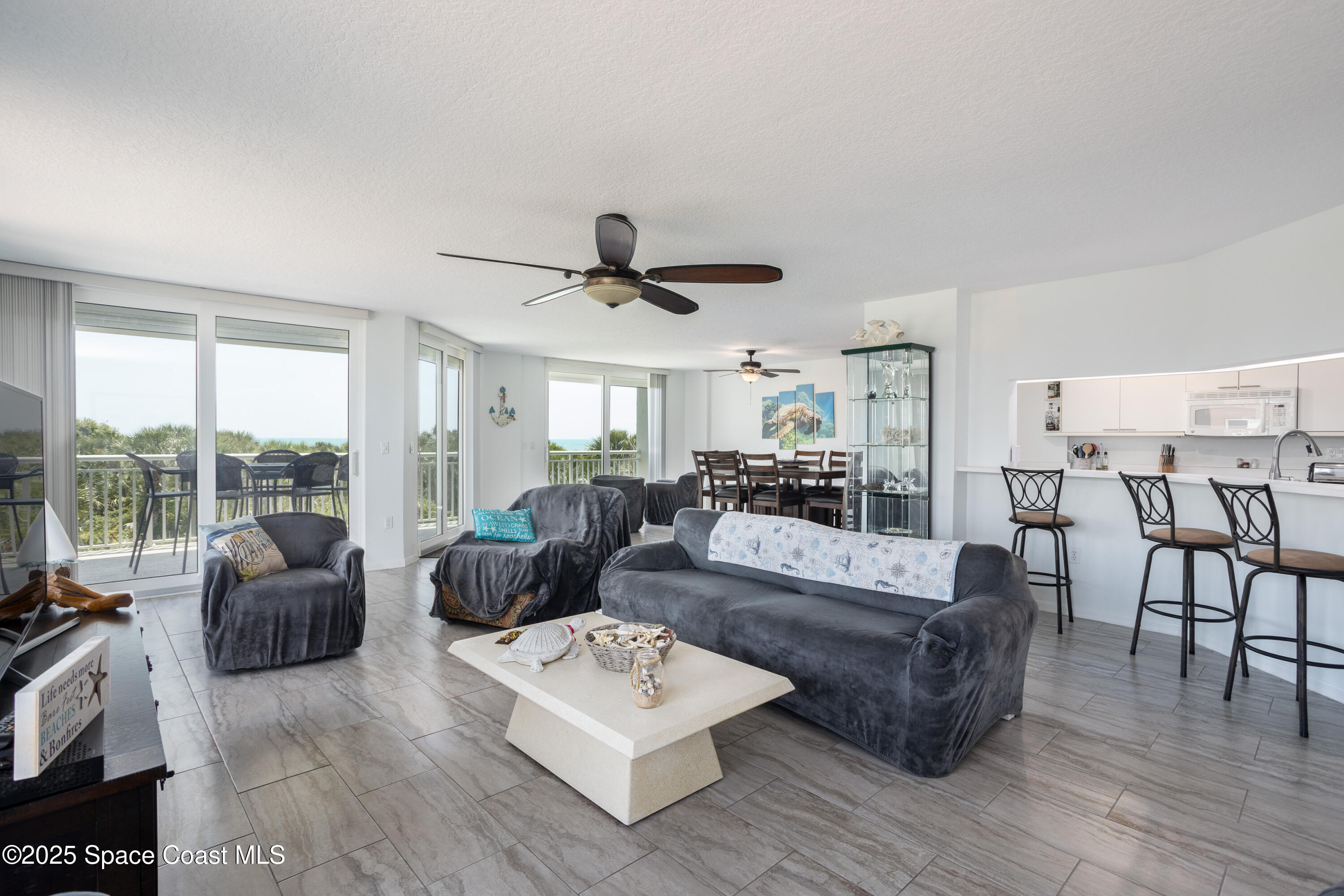 3450 Ocean Beach Boulevard, Unit 201 Cocoa Beach, FL 32931 - Photo 14 of 48 a living room with furniture and a large window