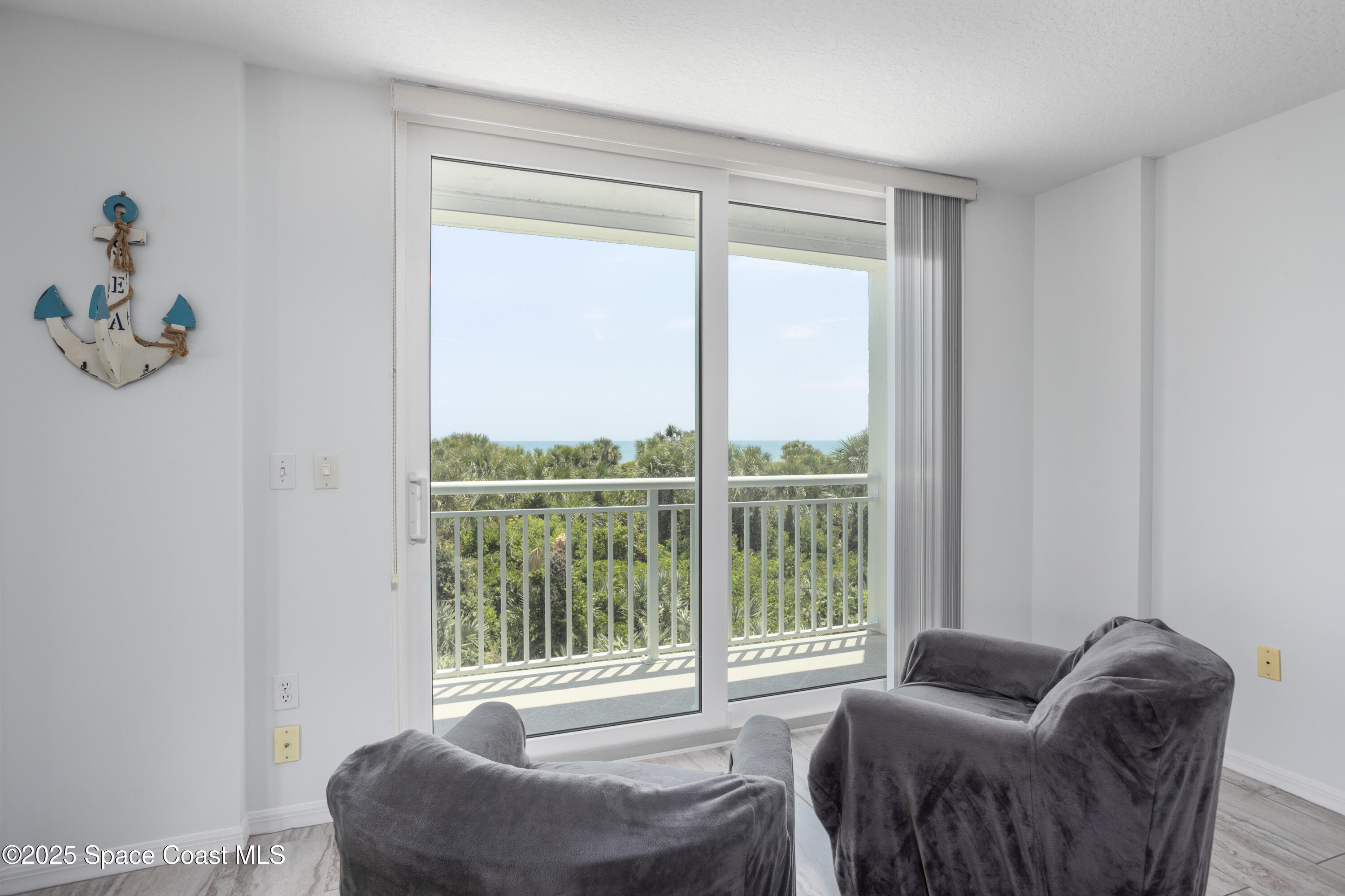 3450 Ocean Beach Boulevard, Unit 201 Cocoa Beach, FL 32931 - Photo 17 of 48 a living room with furniture and a window