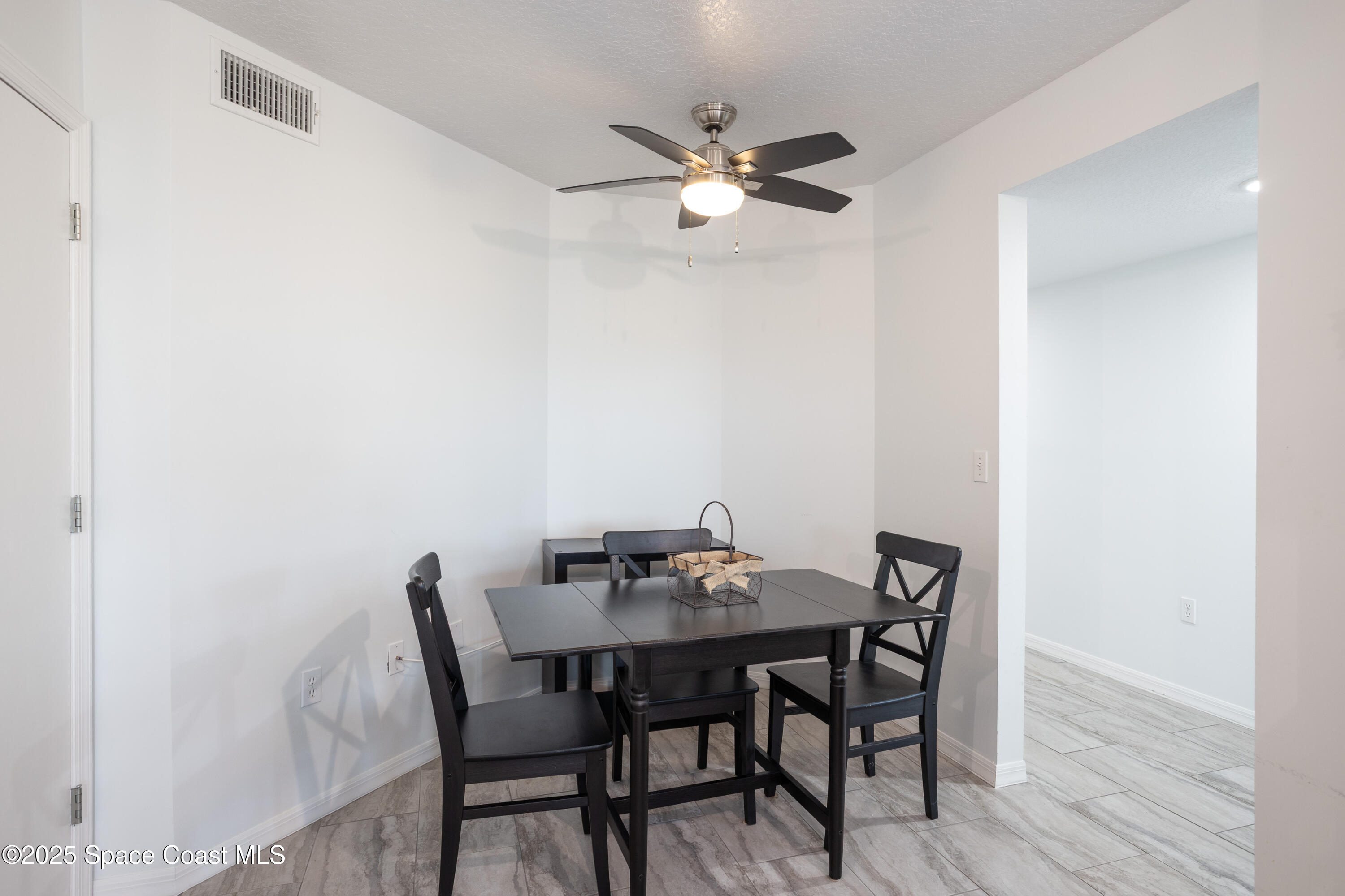 3450 Ocean Beach Boulevard, Unit 201 Cocoa Beach, FL 32931 - Photo 19 of 48 a view of a dining room with furniture and wooden floor