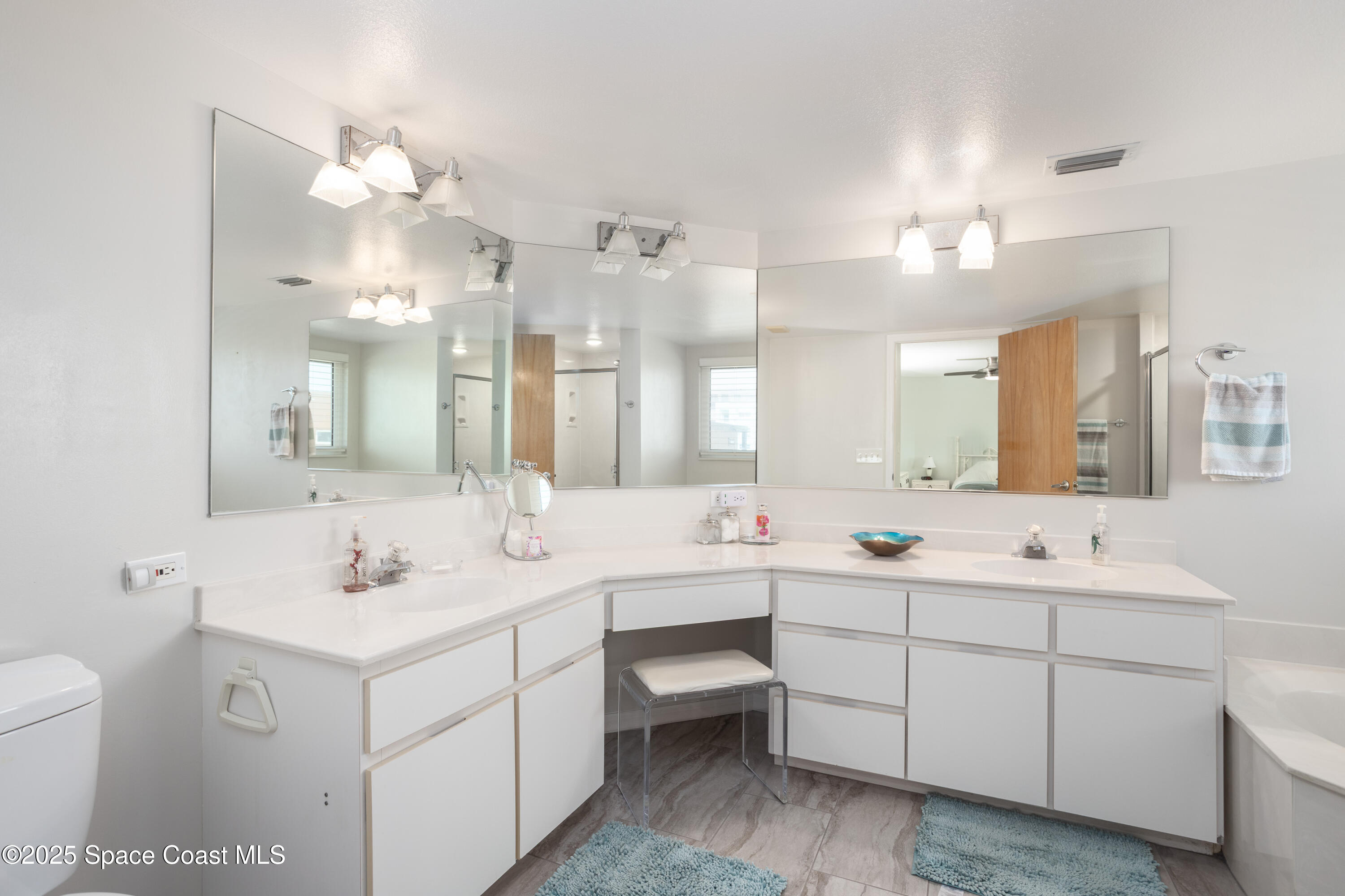 3450 Ocean Beach Boulevard, Unit 201 Cocoa Beach, FL 32931 - Photo 22 of 48 a bathroom with a double vanity sink mirror and toilet