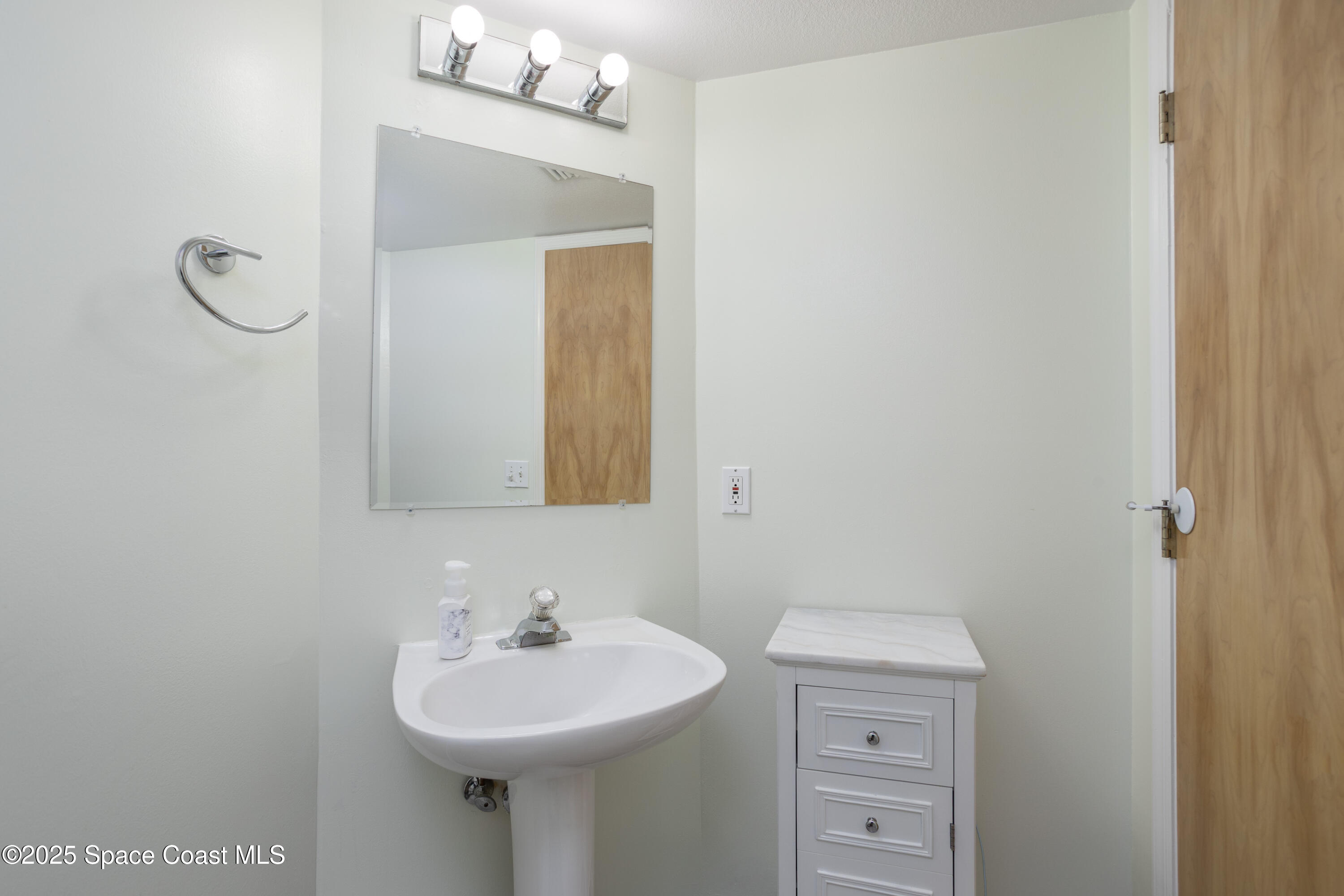 3450 Ocean Beach Boulevard, Unit 201 Cocoa Beach, FL 32931 - Photo 26 of 48 a bathroom with a sink a mirror and vanity