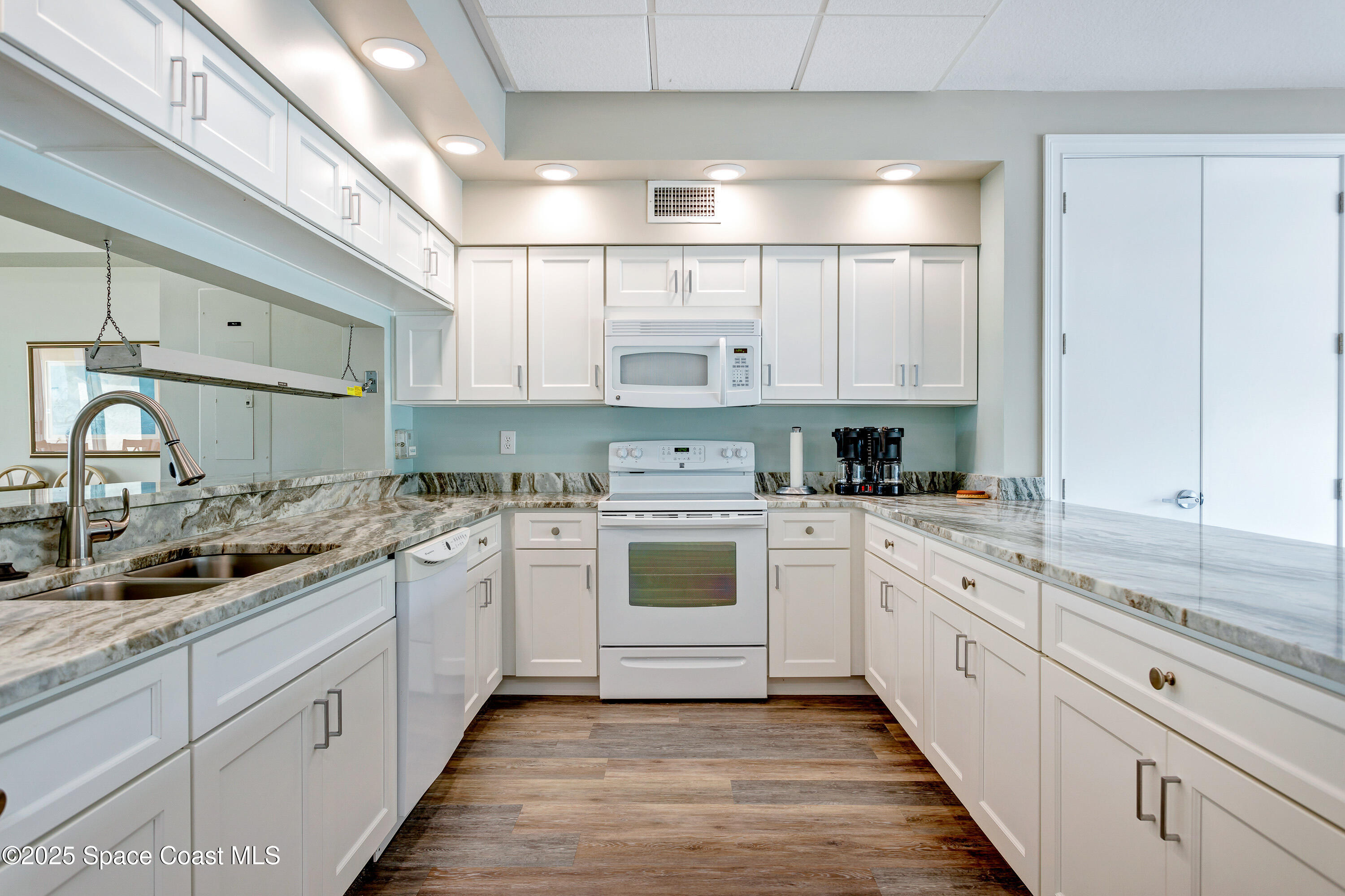 3450 Ocean Beach Boulevard, Unit 201 Cocoa Beach, FL 32931 - Photo 43 of 48 a large kitchen with a stove top oven