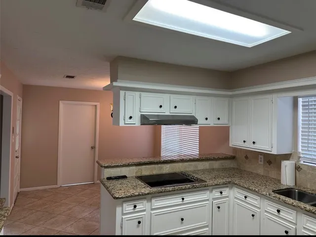 a kitchen with granite countertop a sink and a stove