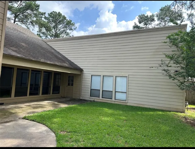 a view of a house with a yard and large tree
