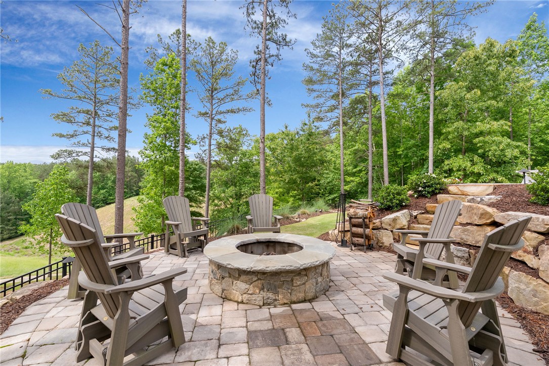 119 Drewberry Lane Sunset, SC 29685 - Photo 28 of 42 This spacious outdoor area features a built-in fire pit, perfect for gatherings amidst lush greenery.