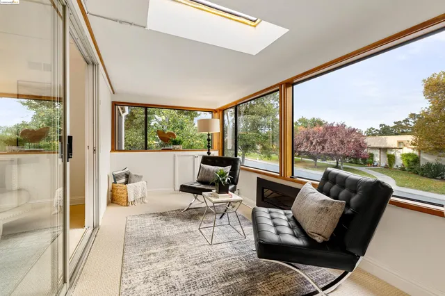 a living room with furniture and a floor to ceiling window