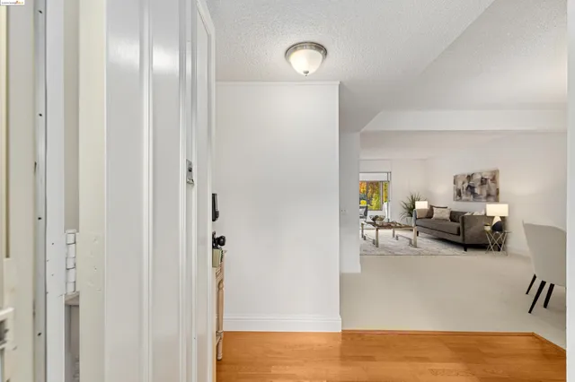 a view of a hallway with wooden floor and a dining room