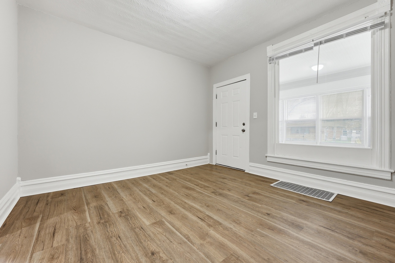 835 Oak Street Elgin, IL 60123 - Photo 6 of 41 a view of an empty room with wooden floor and a window