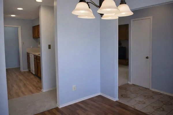 an empty room with wooden floor chandelier fan
