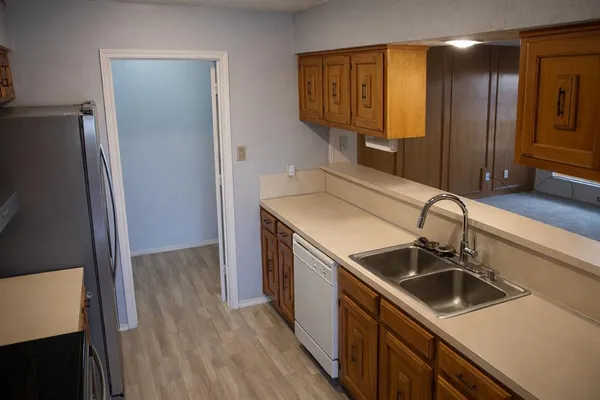 a kitchen that has a sink a refrigerator and cabinets