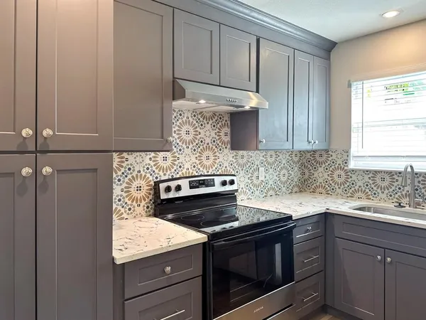 a kitchen with granite countertop cabinets stainless steel appliances and a sink