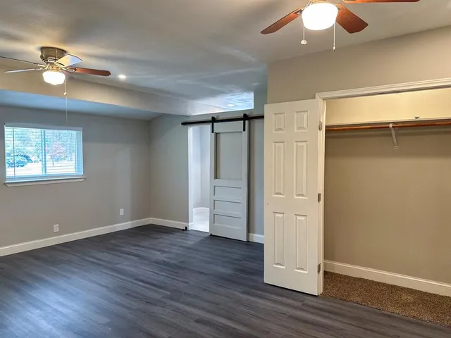a view of an empty room with wooden floor