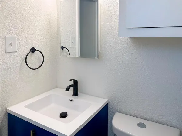 a bathroom with a sink a toilet and a mirror