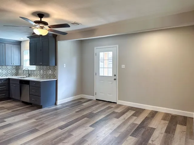 a view of kitchen and kitchen with granite countertop cabinets