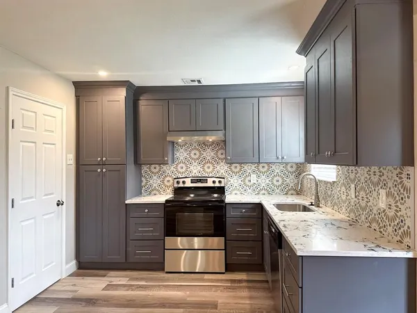 a kitchen with granite countertop a sink and cabinets
