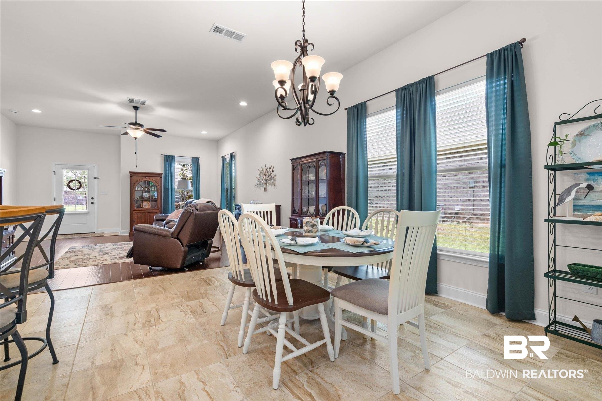 1270 Surrey Loop Foley, AL 36535 - Photo 7 of 27 Open-concept living and dining areas featuring tile flooring, large windows with blinds, a multi-light chandelier, and recessed lighting