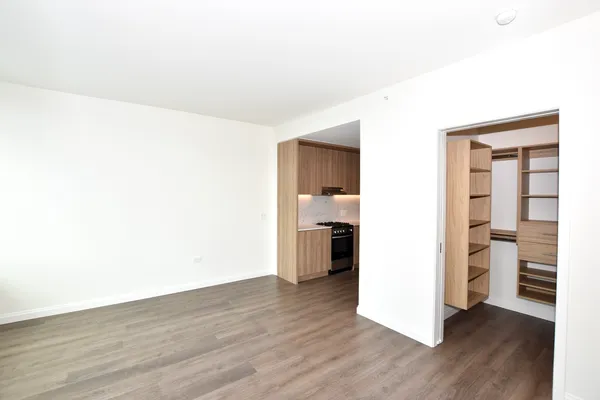 a view of a kitchen with a fridge and wooden floor