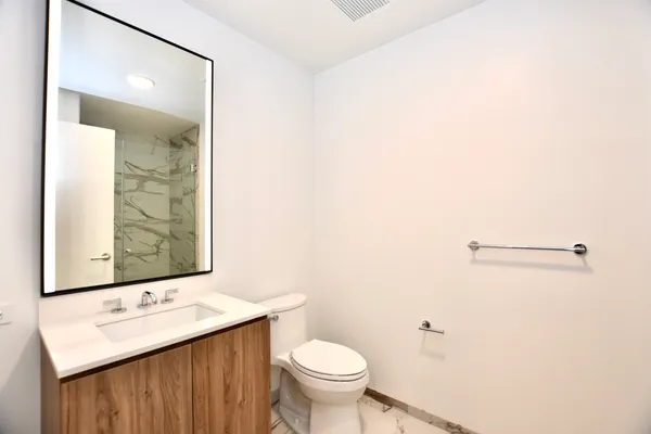 a bathroom with a sink a toilet and mirror