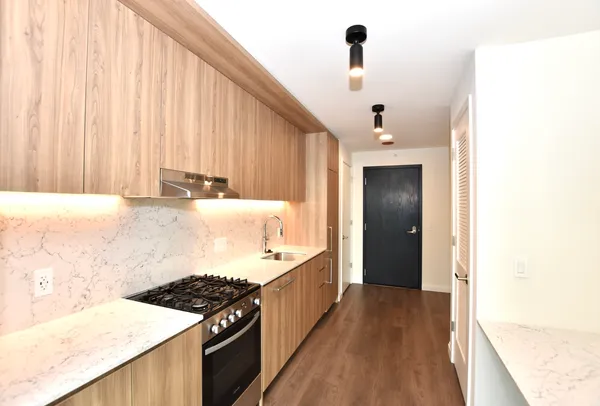 a kitchen with a stove and a wooden floor