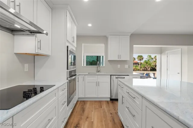 a view of a hallway with wooden floor and a bathroom
