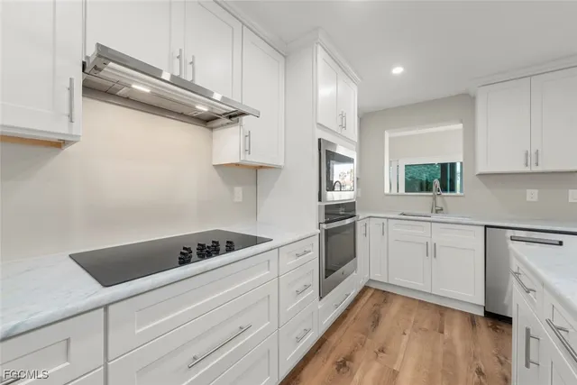 a view of a kitchen with wooden floor and a sink