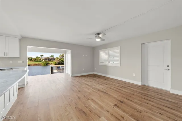 a view of a hallway with wooden floor and a bathroom