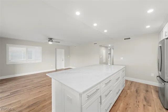 a kitchen with stainless steel appliances white cabinets and a stove top oven