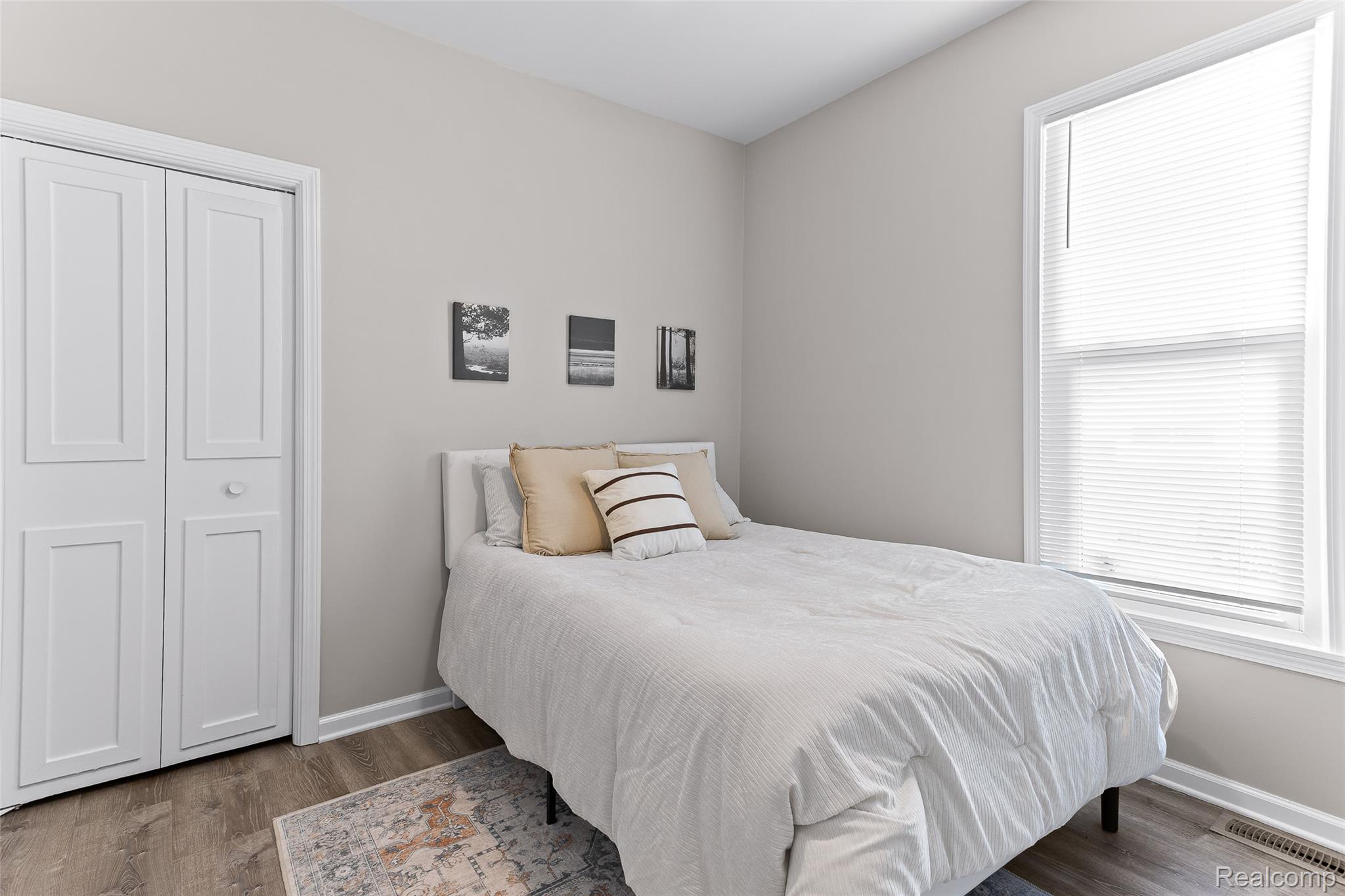 35025 Wick Road Romulus, MI 48174 - Photo 13 of 17 Light-filled room featuring wood-finish flooring, a white bi-fold closet, and neutral wall tones