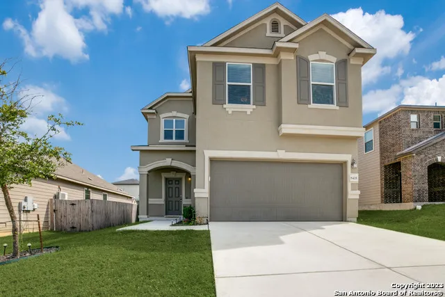 a front view of a house with a yard and garage